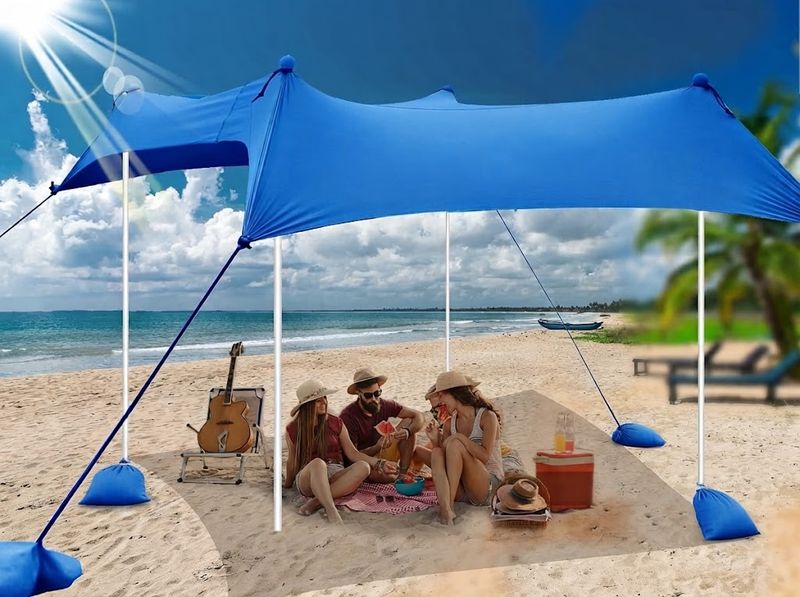 Friends seated under a pitched blue UMARDOO beach canopy