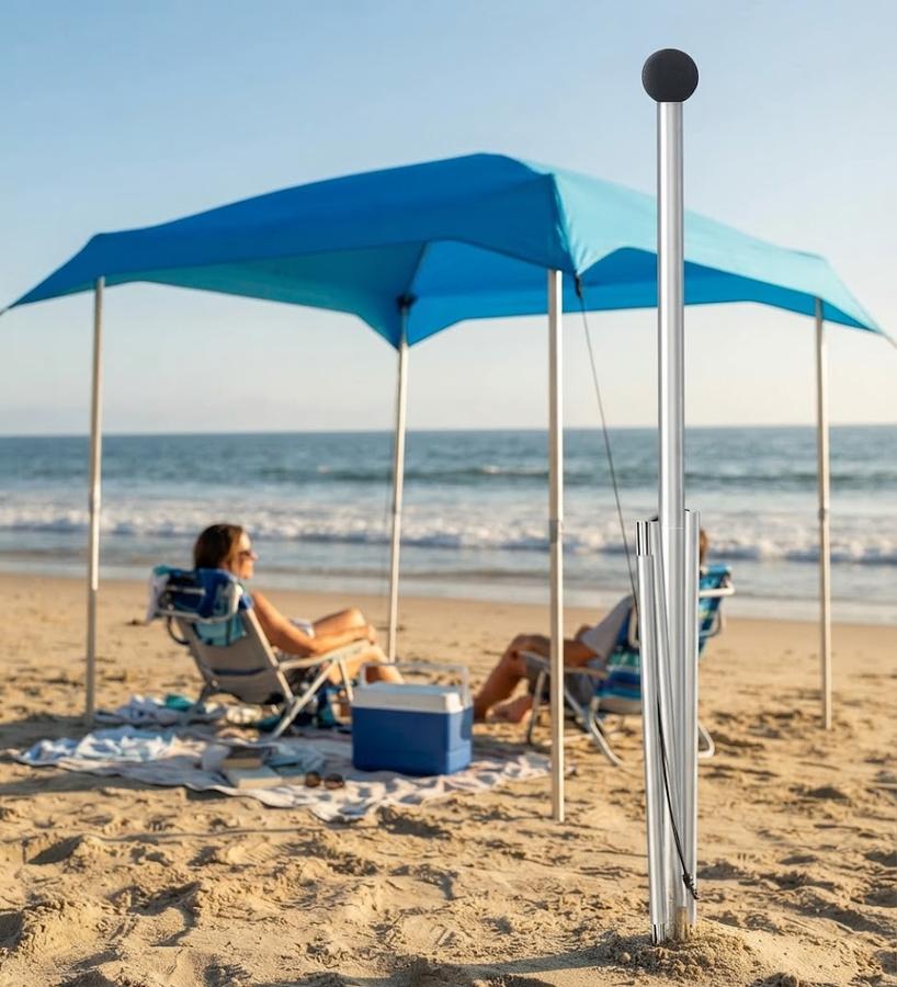 Aluminium canopy pole standing in sand beside a pitched UMARDOO shelter